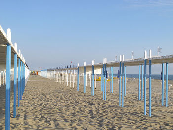 Wooden posts on beach against clear sky