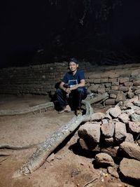 Portrait of young man sitting on rock