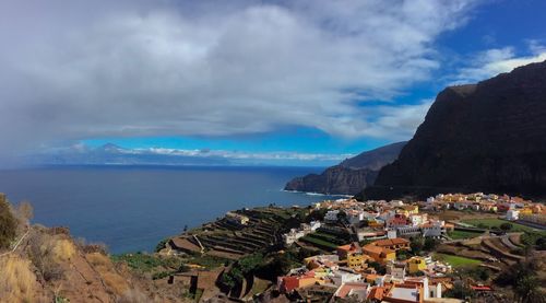 High angle view of townscape by sea against sky