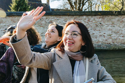 Two beautiful girls are sailing on a tourist boat along the city canal.