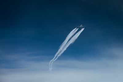 Low angle view of airplane flying against sky