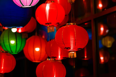 Illuminated lanterns hanging at market stall