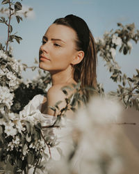 Portrait of young woman against plants