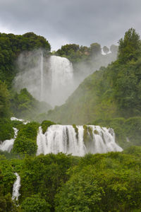 Scenic view of waterfall against sky