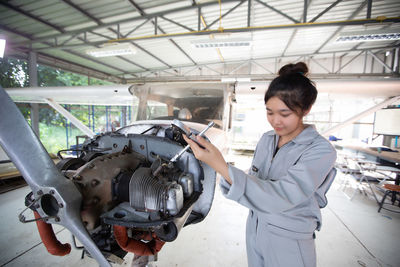 Woman repairing helicopter in workshop