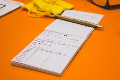 Close-up of book and pen on table