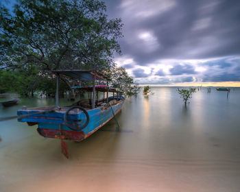 Boat moored in lake against sky