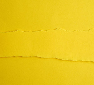 Background of layered yellow torn paper with a shadow, backdrop and template for designer, close up