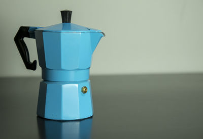 Close-up of blue coffee pot on table
