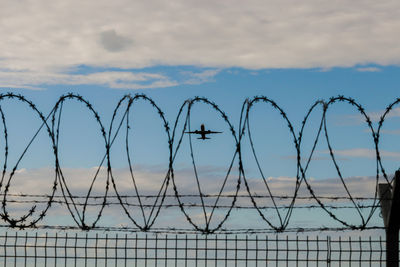 Low angle view of barbed wire against sky