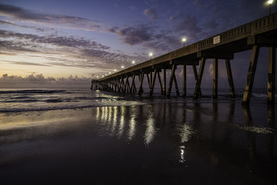 Bridge over sea against sky during sunset