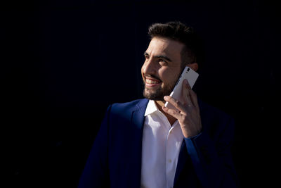 Young businessman using cell phone near the office