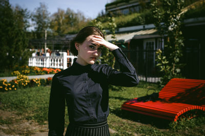 Woman standing at lawn during sunny day