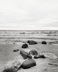 Surface level of rocks on beach against sky