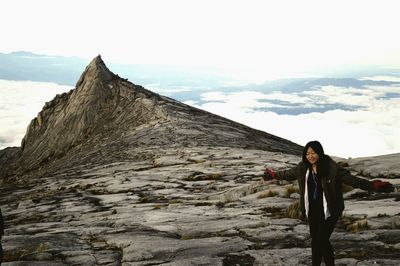 Portrait of woman standing on mountain against sky