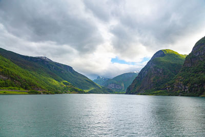 Scenic view of lake by mountains against sky