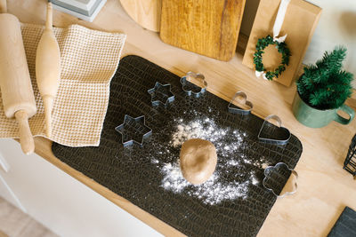 Gingerbread cookie dough is on the table and cutting molds, wooden rolling pins and a towel 