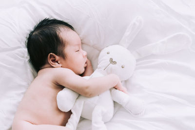 High angle view of baby sleeping on bed