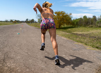 Rear view of woman running on road