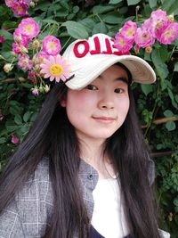 Portrait of teenage girl with pink flowers