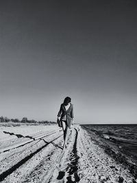 Man walking on land against clear sky