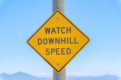 Low angle view of road sign against clear sky