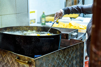 Midsection of person preparing food in kitchen