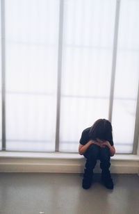 Full length of child sitting against wall