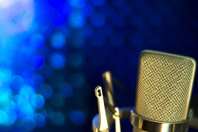 Close-up of microphone against defocused illuminated background