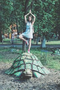 Portrait of smiling young woman standing against trees