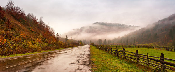 Road amidst field against sky