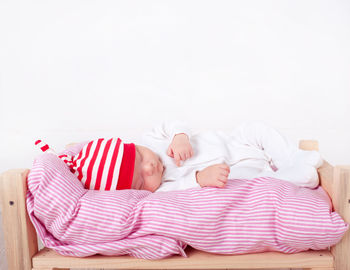 Cute baby sleeping on small bed at home