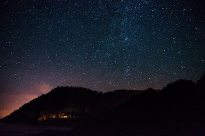 High angle view of silhouette mountains against starry sky