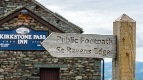 Close-up of road sign against building