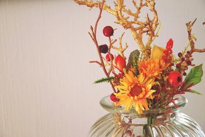 Close-up of flower vase on table against wall