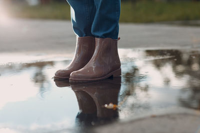 Low section of person standing on wet lake