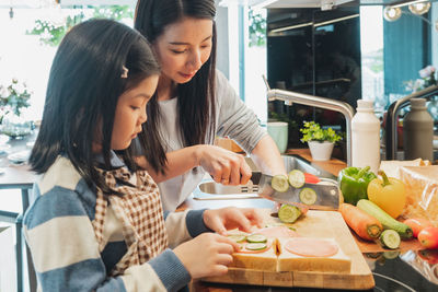 Mother and girl having food at home