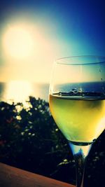 Close-up of beer in glass on table against sunset