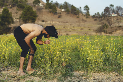 Young indian farmer working in the fields, growing crops. farming and agriculture concept.