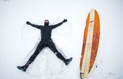Surfer makes snow angel in maine winter snow storm