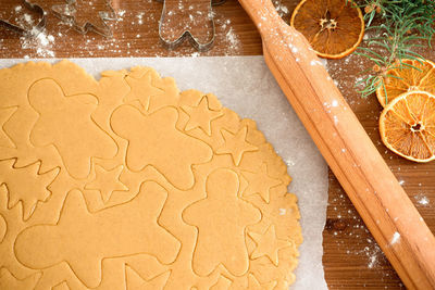 Cut gingerbread out of the dough using a gingerbread mold, top view, raw dough with cinnamon 