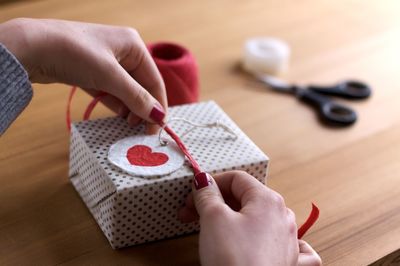 Cropped hands tying label on gift box