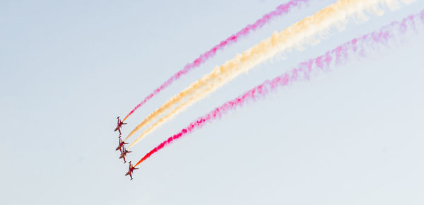 Low angle view of airshow against clear sky