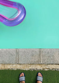 Low section of person standing by swimming pool