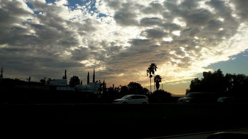 Silhouette of road against cloudy sky