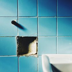 Close-up of blue paint on floor against white wall