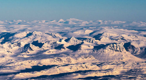 Aerial view of snowcapped mountains against sky