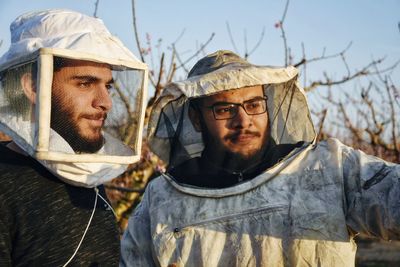Portrait of two friends wearing special costumes to protect them from bees