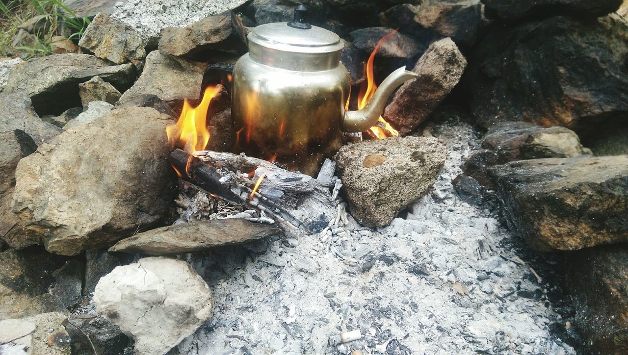 rock - object, flame, burning, heat - temperature, no people, close-up, high angle view, container, sunlight, outdoors, day, water, still life, stone - object, bottle, fire - natural phenomenon, food and drink, motion, reflection