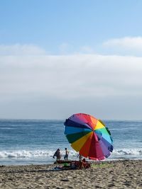 People on beach against sky